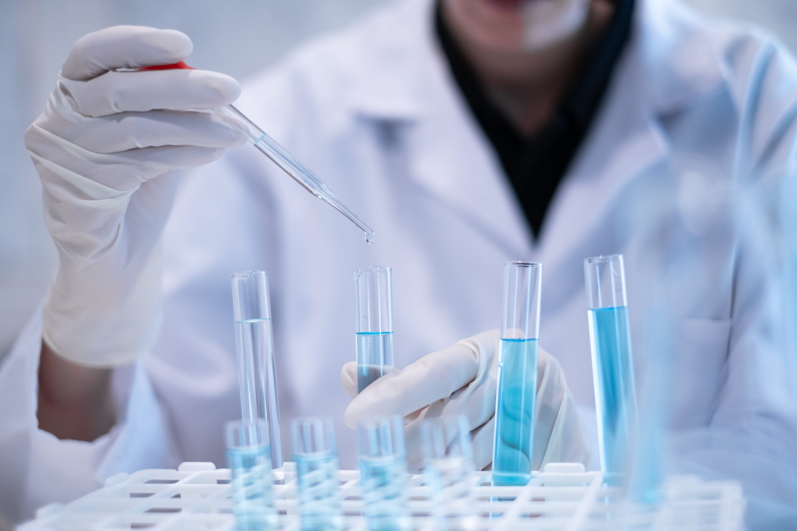 試験管に試薬を入れる研究者